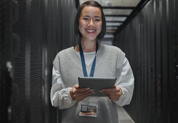 Foto ritratto di donna asiatica sorriso e tablet del tecnico nella sala server per la manutenzione della rete o dei sistemi in ufficio ingegnere femminile felice che sorride per la gestione dell'alimentazione o l'amministrazione dei dati