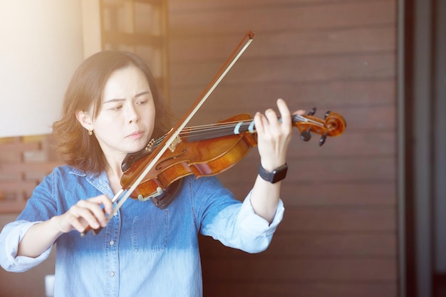 アジアの女性がバイオリンをカジュアルに練習
