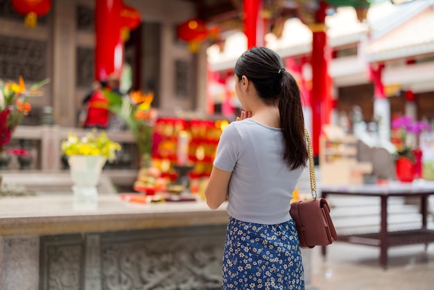 アジア人女性が中国の寺院で祈っている