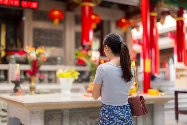 アジア人女性が中国の寺院で祈っている