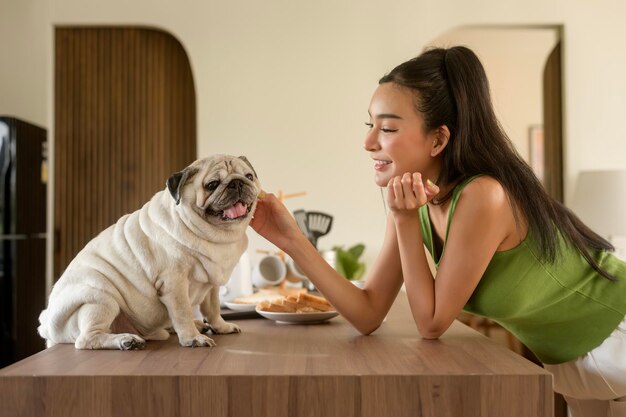 Asian woman preparing coffee and toast bread for breakfast enjoy with dog