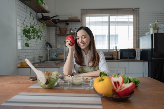asian woman preparing salad in the kitchen at home