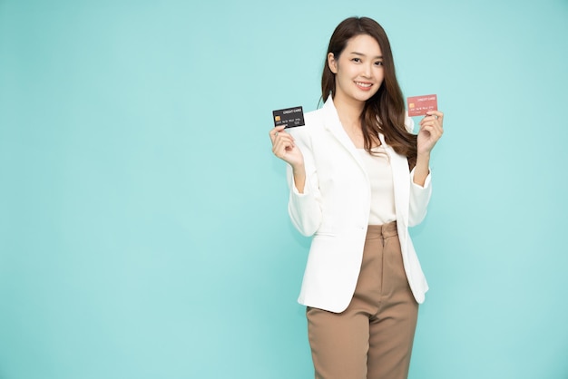 Asian woman presenting credit card isolated on green background