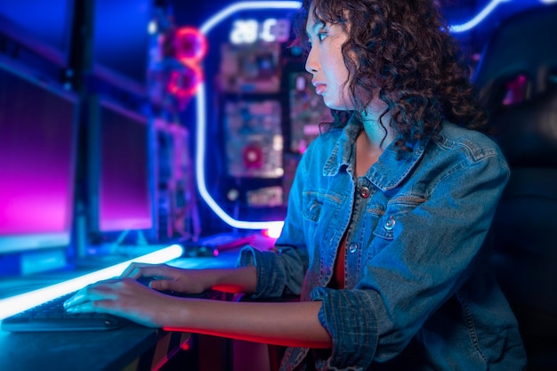 아시아 여성 프로그래머가 그녀의 컴퓨터실 미래 기술 개념에서 일하고 있습니다.