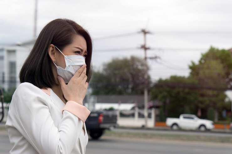 Photo 保護マスクのアジアの女性は大気汚染で街で悪い感じ。