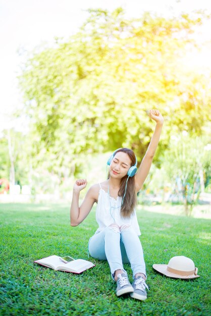 Asian woman reading book alone in the park on spring day. Relax and recreation. Outdoor activity and lifestyle on holiday.