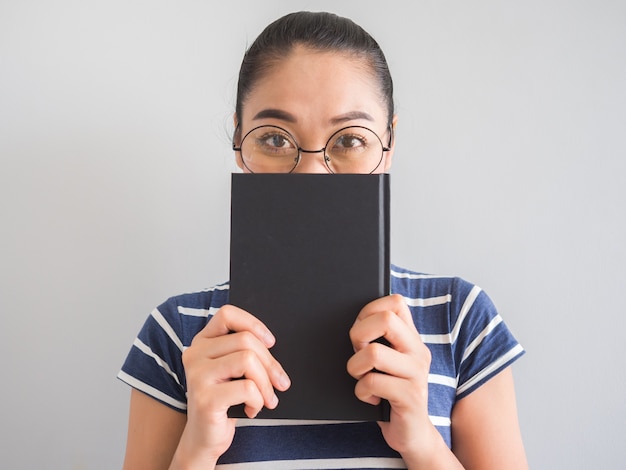 Asian woman reading book and thinking for ideas.