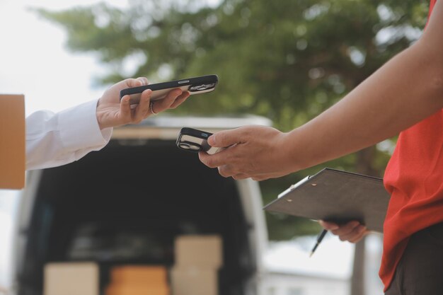 Asian Woman Receiving Product from delivery man at Home Young Owner Woman Order Product from Smartphone Application Woman with Online Business or SME Concept