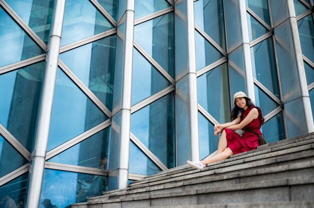 Asian woman in red dress at modern building, female girl with urban city lifestyle