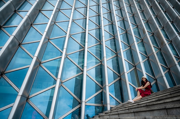 Donna asiatica in abito rosso in un edificio moderno, ragazza con stile di vita urbano della città