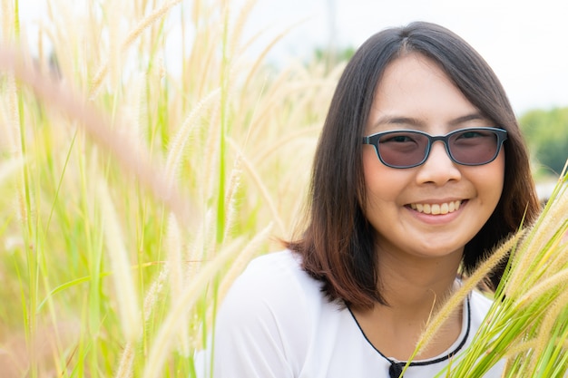 アジアの女性は芝生のフィールドでリラックスします。