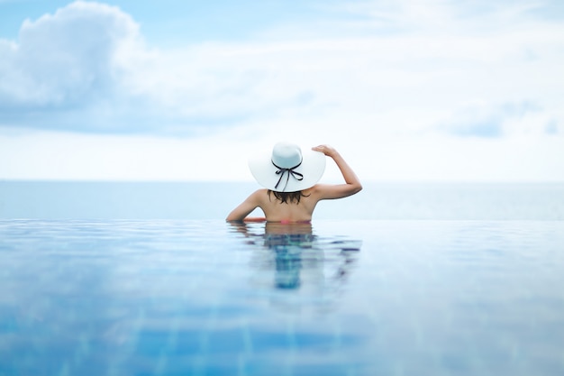 Asian woman relax in pool on beach