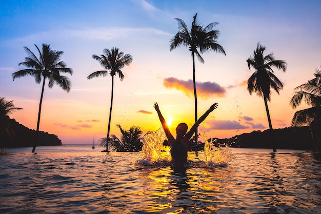 Asian woman relax in pool on beach