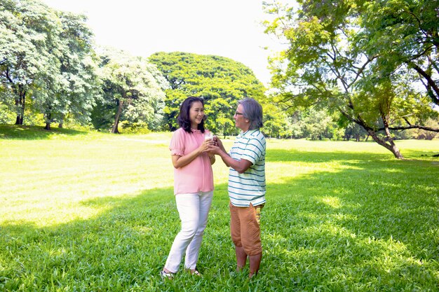 Asian woman relax time in park. A man sent milk for woman.