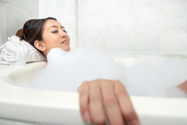 Asian woman relaxing on the bathtub