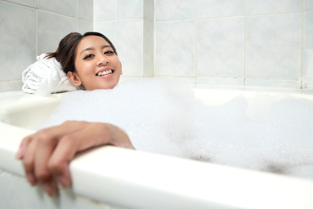 Asian woman relaxing on the bathtub