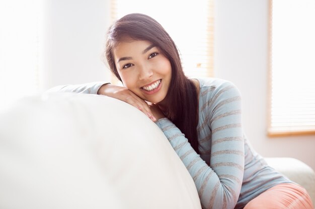 Asian woman relaxing on couch