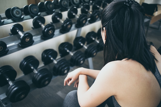 Asian woman resting from exercise in the gym.