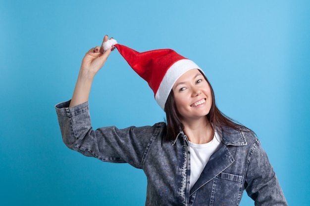 Foto donna asiatica in un cappello da babbo natale alza il cappello