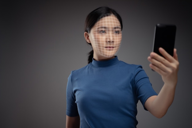 Asian woman scans face by smart phone using facial recognition system