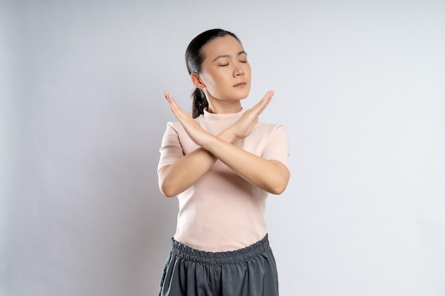 Asian woman showing arms crossed making stop sign