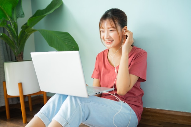 Asian woman sitting on the floor while she working from home