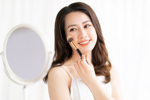 Photo asian woman sitting makeup in front of mirror