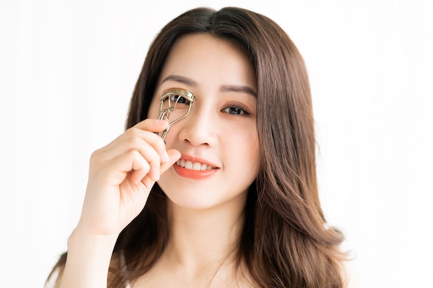 Asian woman sitting makeup in front of mirror