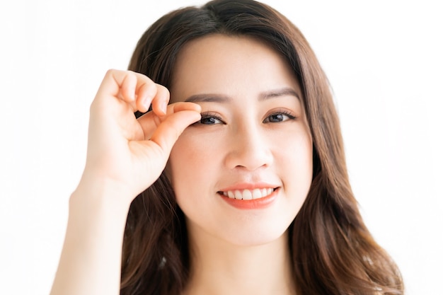 Asian woman sitting makeup in front of mirror