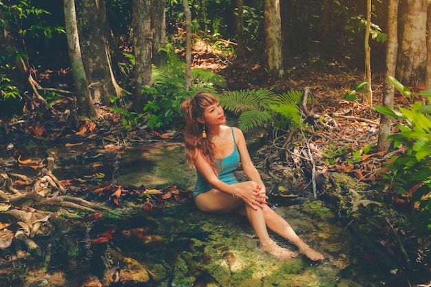 Photo asian woman sitting near the waterfall enjoy the nature travel lifestyle concept