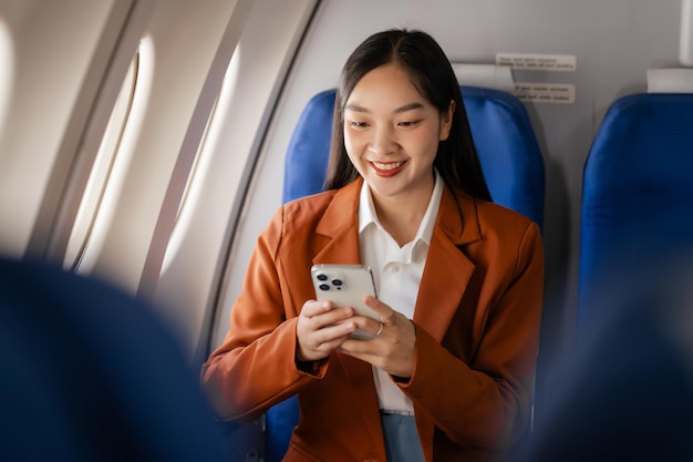 Photo asian woman sitting in a seat in airplane and looking out the window going on a trip vacation travel