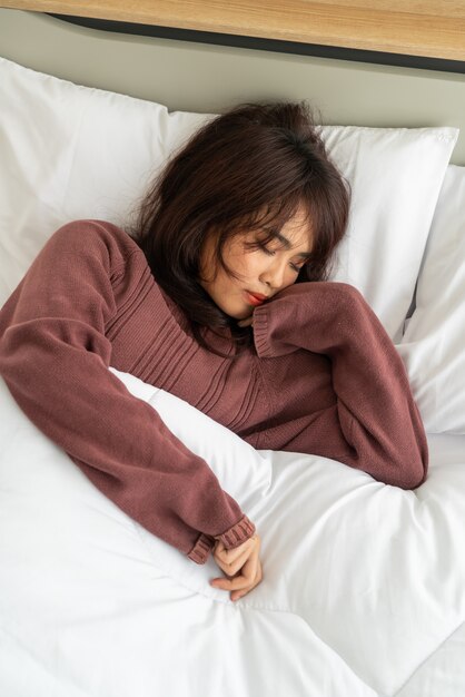 Asian woman sleeping on bed in morning