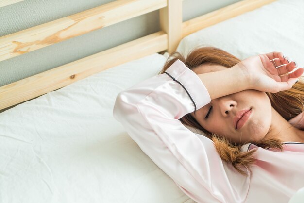 asian woman sleeping on bed