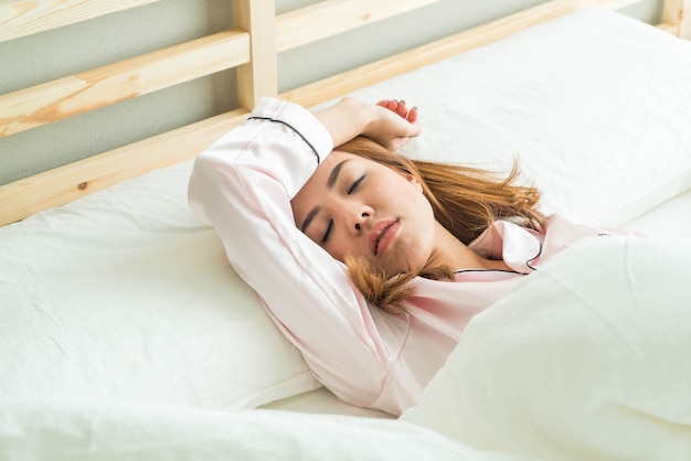 asian woman sleeping on bed