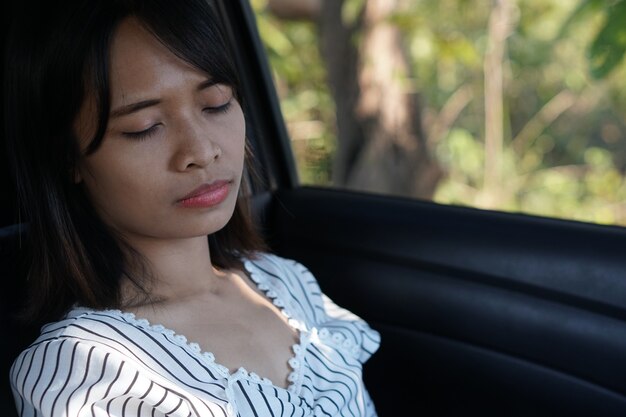 Asian woman sleeping in a car