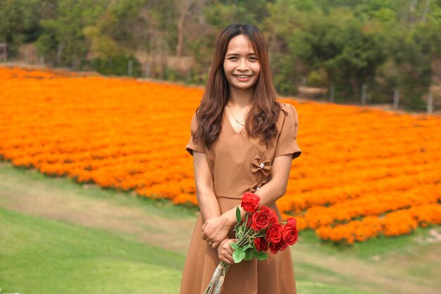 Asian woman smiling happily among beautiful flowers