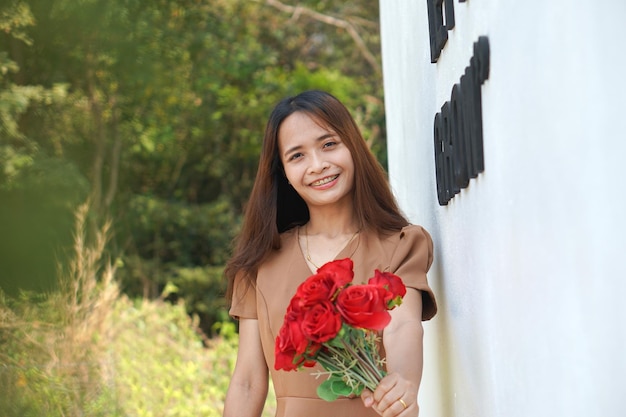 Asian woman smiling happily among beautiful flowers