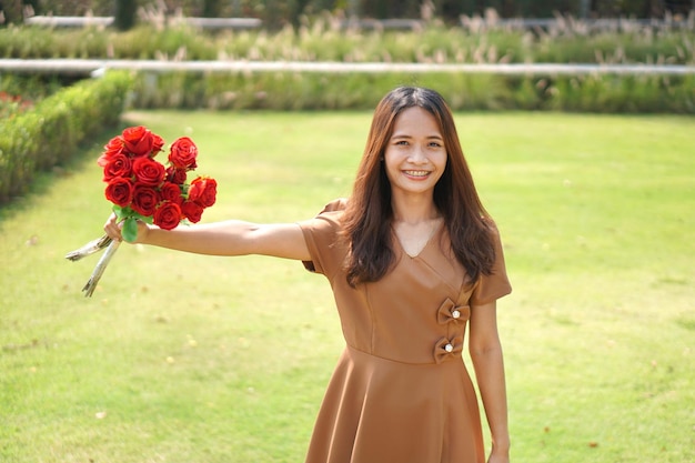 Asian woman smiling happily among beautiful flowers