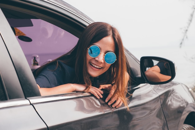 Photo asian woman smilng with the mirror in the car.