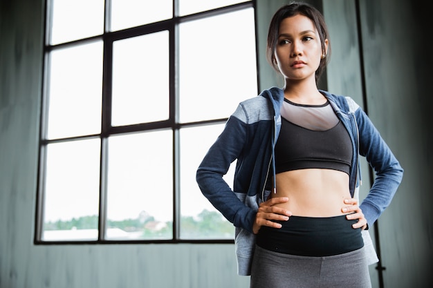 Donna asiatica nell'usura di sport che esamina macchina fotografica