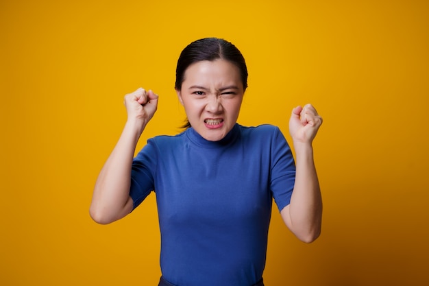 Asian woman standing and angry over yellow.