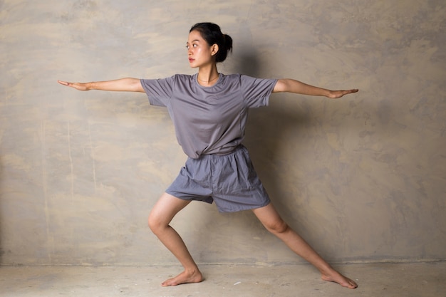 Donna asiatica che sta alla posa di yoga