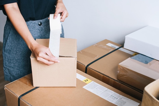 写真 asian woman sticking gum tape on cardboard