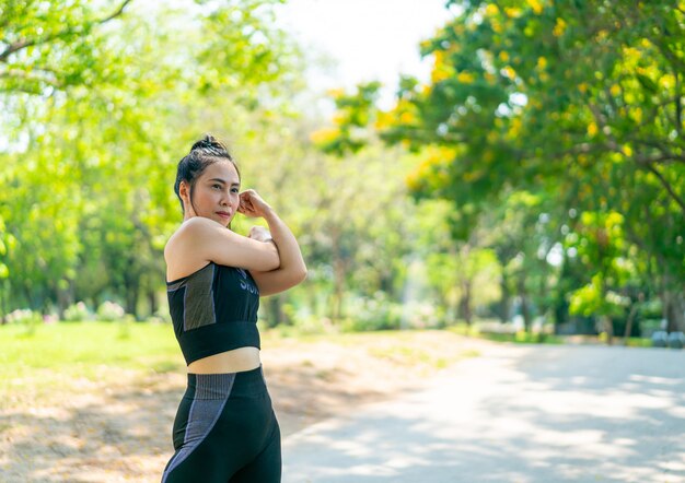 Donna asiatica che allunga al parco