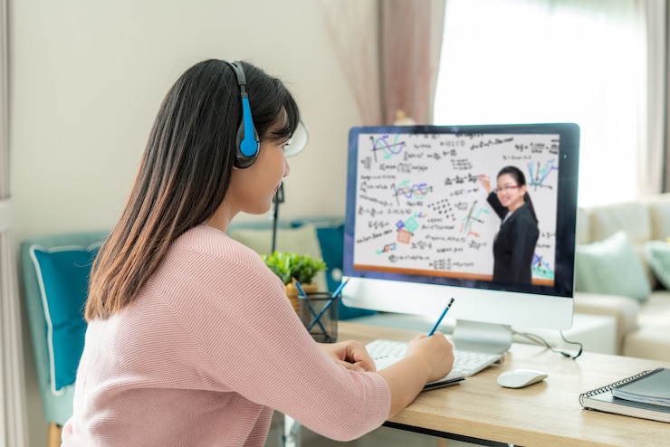 Photo アジアの女性学生ビデオ会議eラーニングと自宅のリビングルームのコンピューター上の教師。