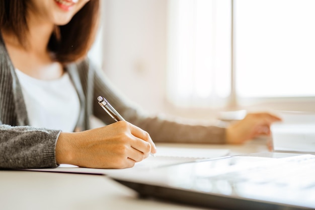 写真 アジアの女子学生は、試験の準備について読んで話し合っています。