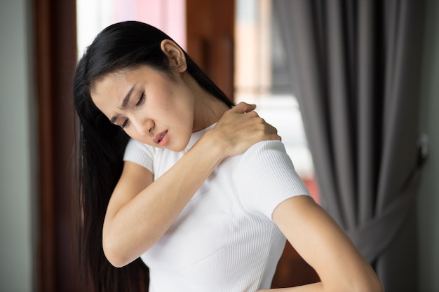 Asian woman suffers from shoulder joint pain or injury