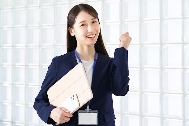 Asian woman in a suit cheering with a fistholding pose