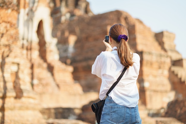 Donna asiatica che prende fotografia e che viaggia