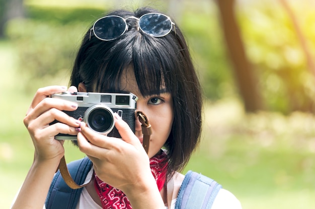Asian woman taking picture with camera
